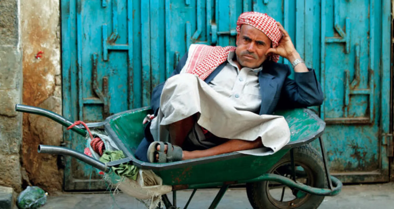 يمني مستريحاً بعد يوم شاق في المدينة القديمة بصنعاء (رويترز)