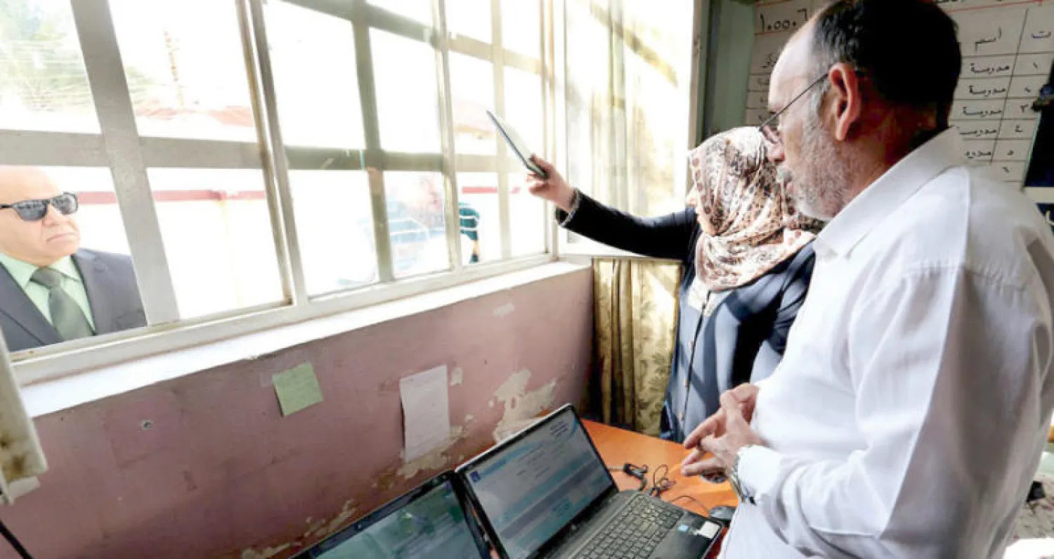 عراقيون يراجعون مكتباً لمفوضية الانتخابات في بغداد لتحديث سجلاتهم (إ.ب.أ)