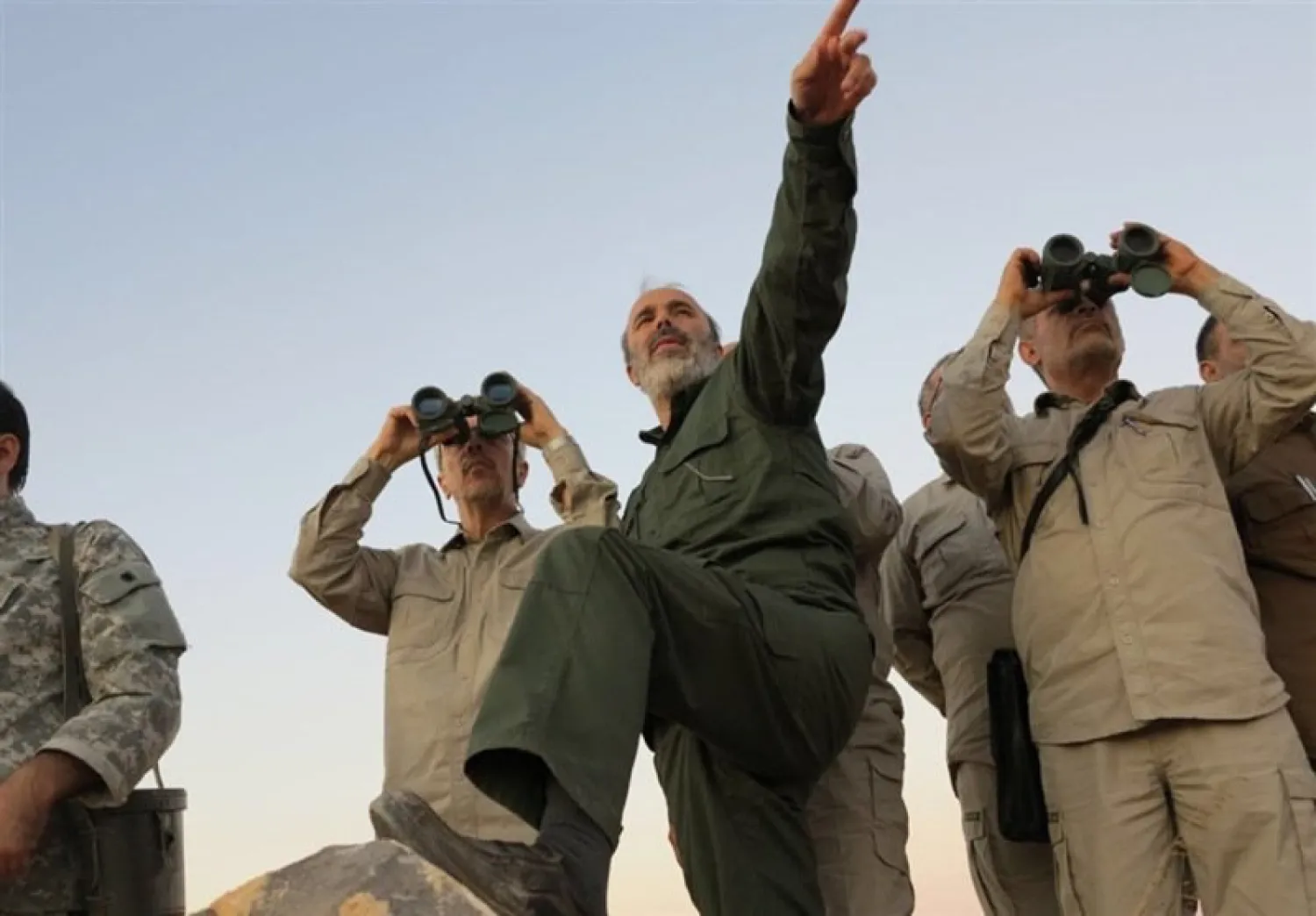Iran's Army Chief of Staff Maj. Gen. Mohammad Bagheri, left, looking into binoculars, and other senior officers from the Iranian military, visit a front line in the northern province of Aleppo, Syria. Photo: AP