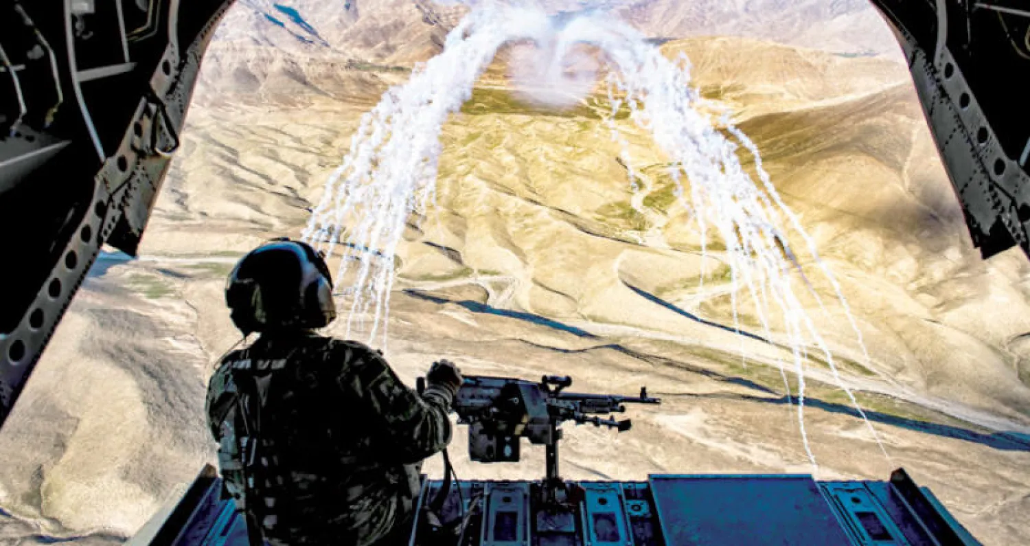 جندي أميركي خلال مشاركته في تدريبات بطائرة «تشينوك» على مطاردة عناصر «طالبان» في سماء أفغانستان أمس (رويترز)
