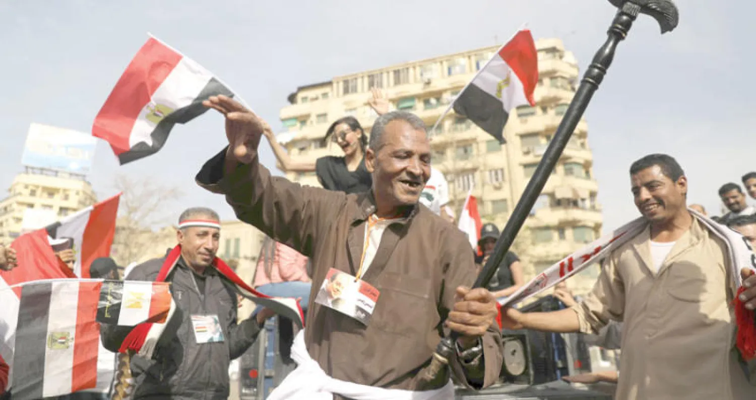 رجال يحتفلون في ميدان التحرير بوسط القاهرة (رويترز) 