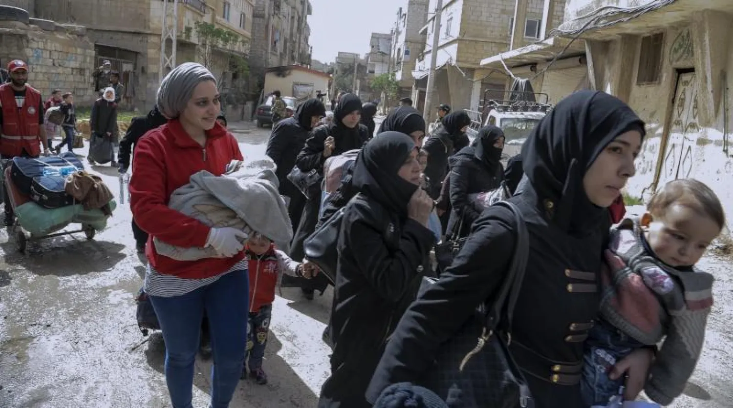 طفلة تغادر الغوطة الشرقية برفقة والدها (أ.ف.ب)