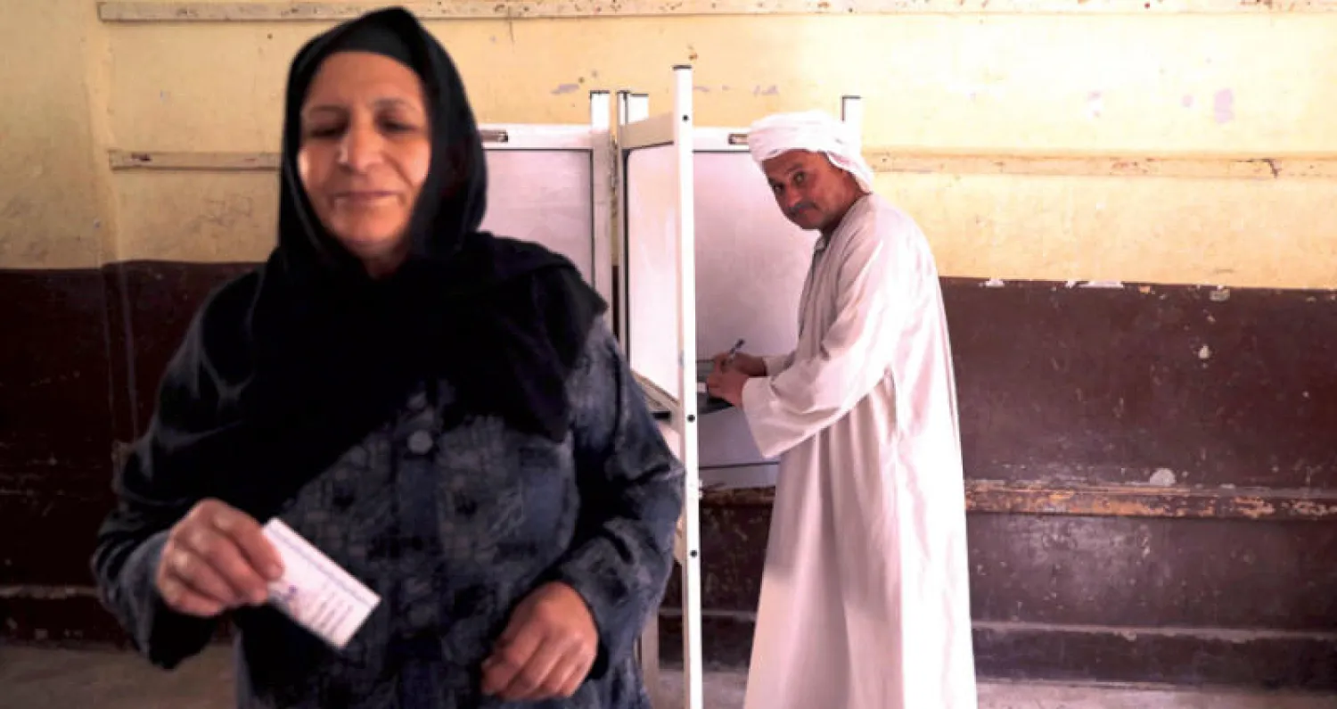 مصريان في مركز اقتراع بالقاهرة أمس (رويترز)