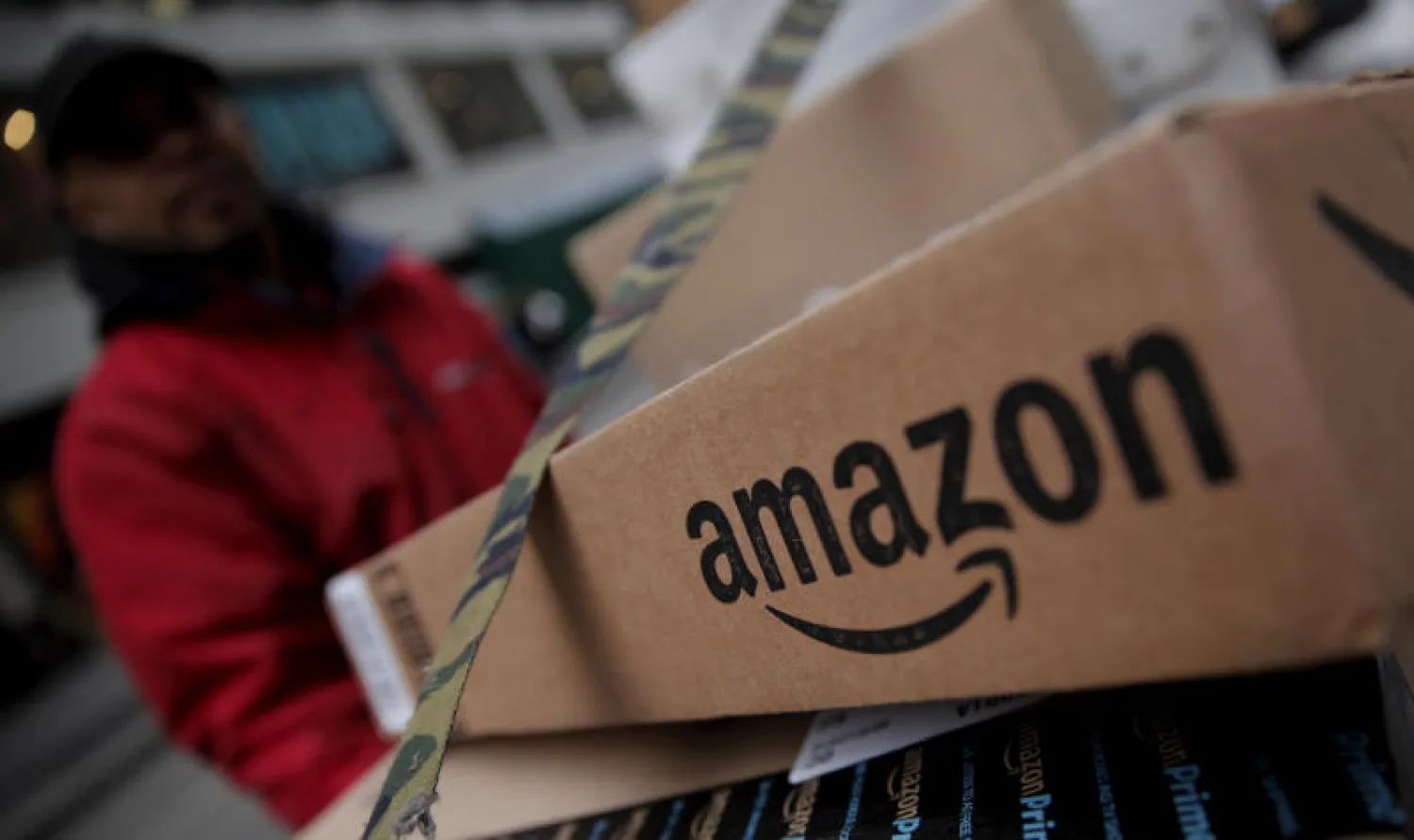 عامل في أمازون يغلف منتجا قبل إرساله من أحد مخازنها في الولايات المتحدة (رويترز)