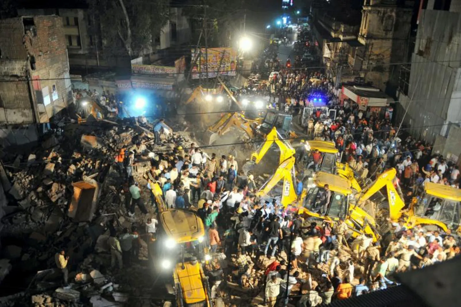 الشرطة وفرق الإنقاذ الهندية خلال عملية البحث عن ناجين تحت أنقاض المبنى المنهار (أ.ف.ب)