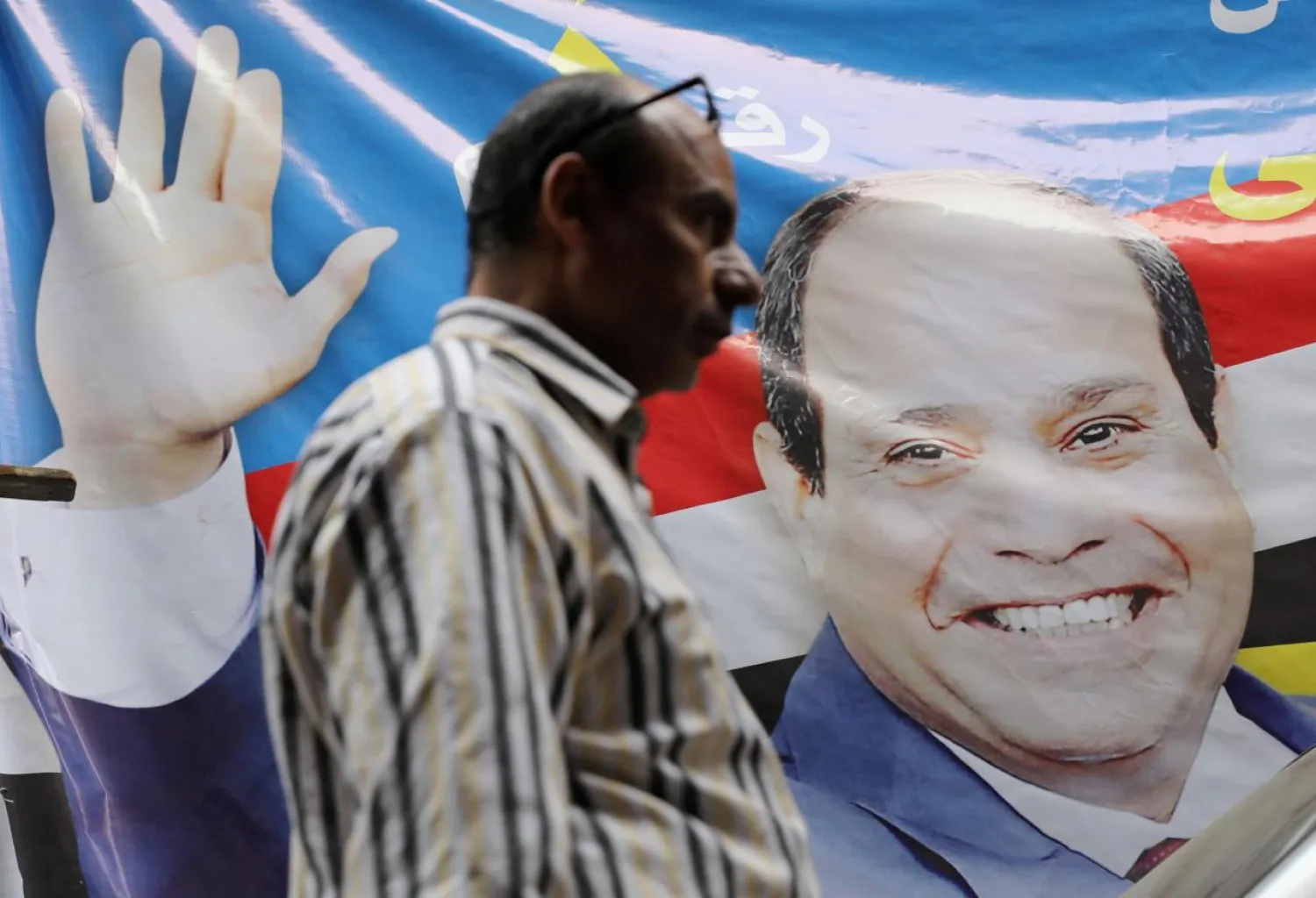 A man walks by a poster of Egyptian President Abdul Fattah al-Sisi in Cairo, Egypt March 19, 2018. (Reuters)