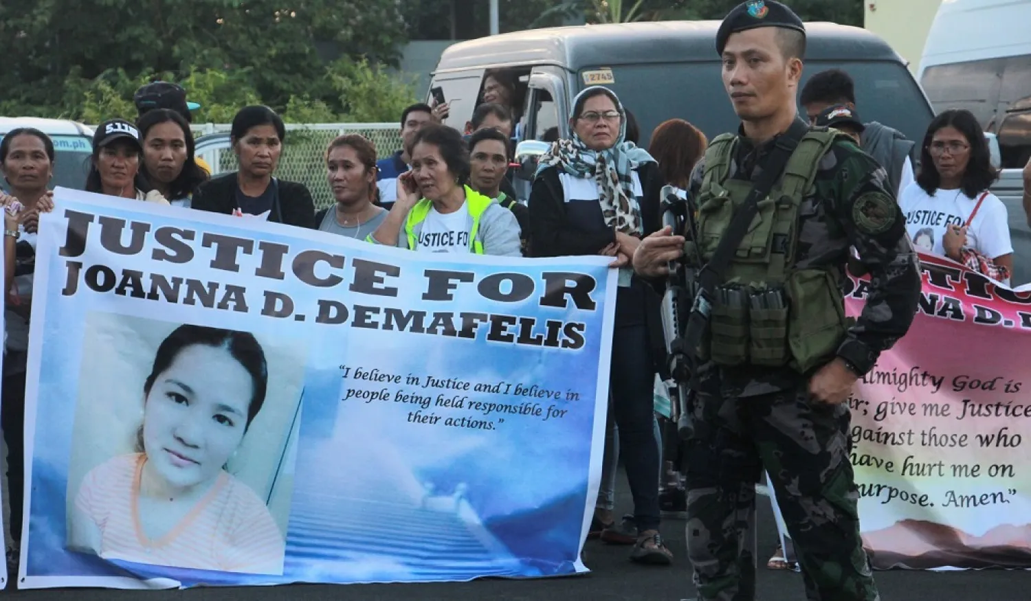 Relatives of Joanna Demafelis hold banners as they wait for the arrival of her body at Iloilo International Airport. (AFP)