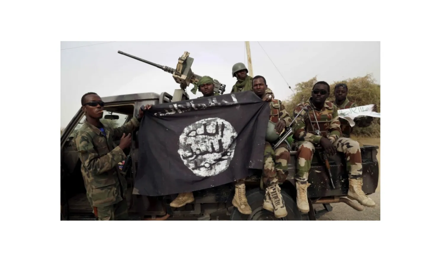 Nigerian soldiers hold up a Boko Haram flag that they had seized in the recently retaken town of Damasak, Nigeria, March 18, 2015. REUTERS/Emmanuel Braun/File Photo
