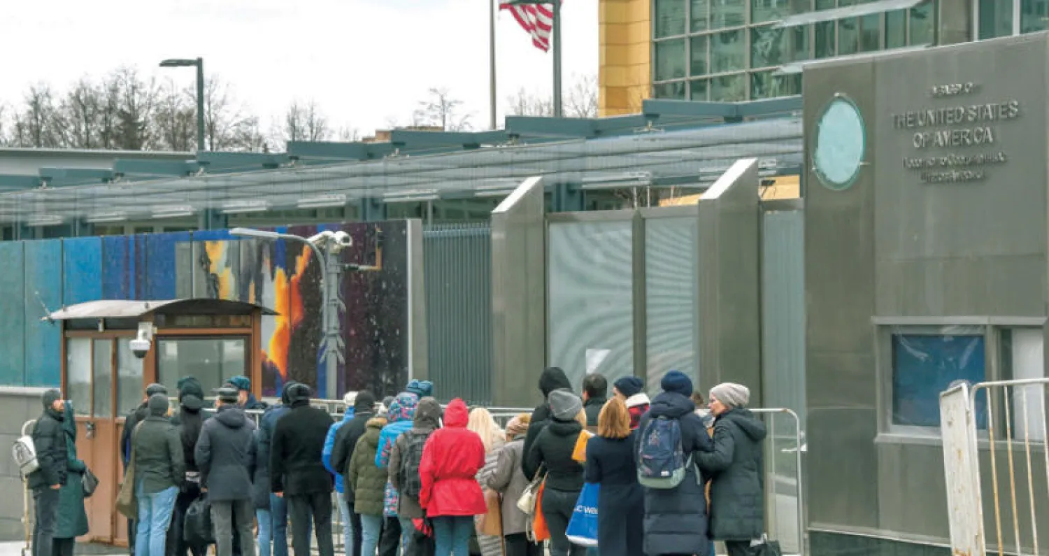 أشخاص ينتظرون تسلم تأشيرات الدخول إلى الولايات المتحدة أمام السفارة الأميركية بموسكو أمس (أ.ف.ب)