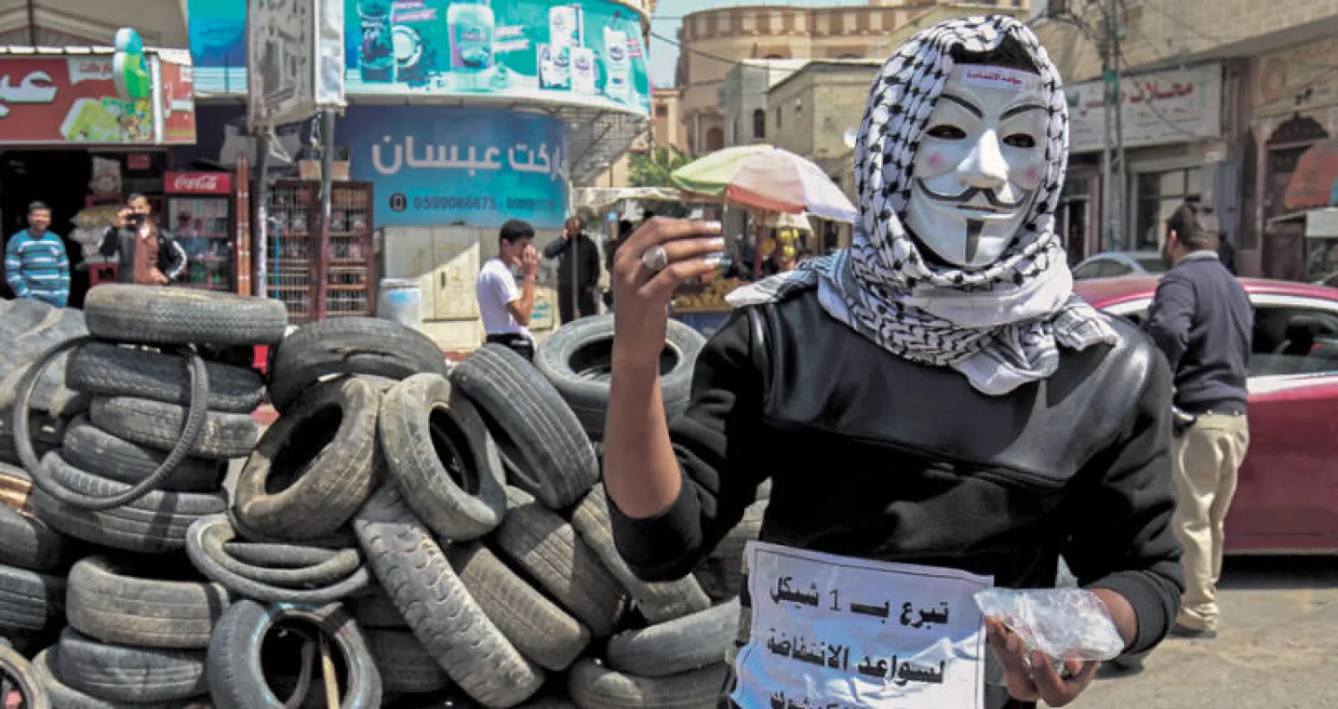 شاب يجمع نقوداً لتأمين نقل إطارات السيارات لدعم «مسيرة العودة» شرق مدينة خانيونس (أ.ف.ب)