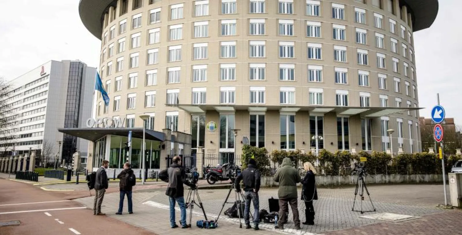 صحافيون ينتظرون خارج مقر منظمة حظر الأسلحة الكيماوية في لاهاي (أ.ف.ب)