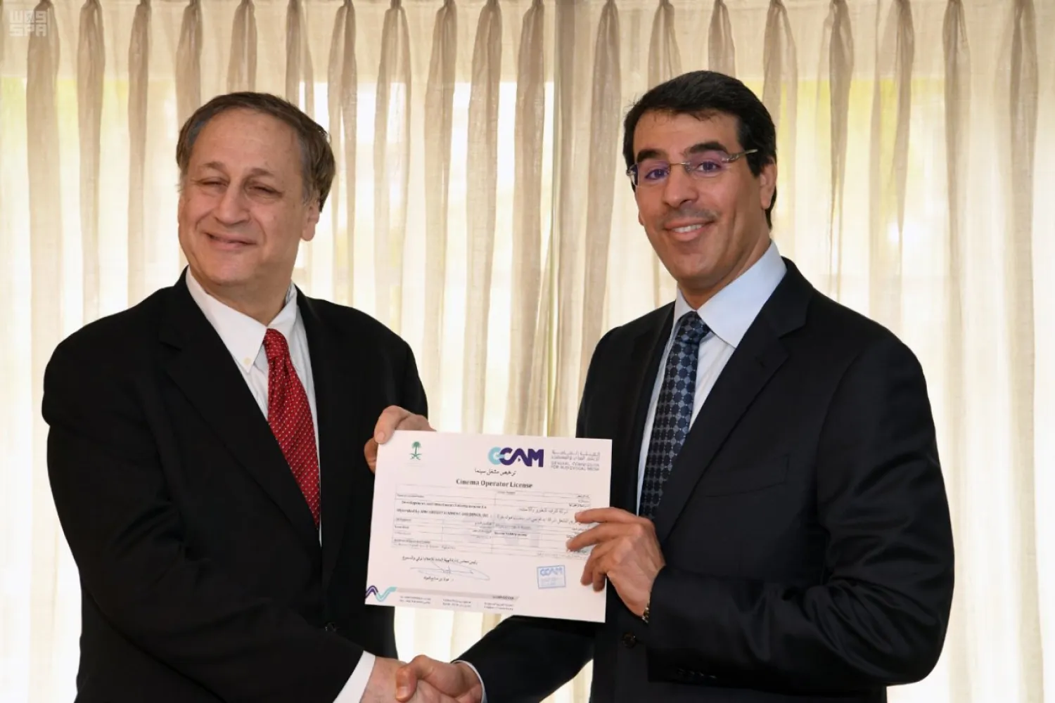 The Saudi Information Minister grants the first license to operate a movie theater in the Kingdom to AMC Entertainment . (SPA)