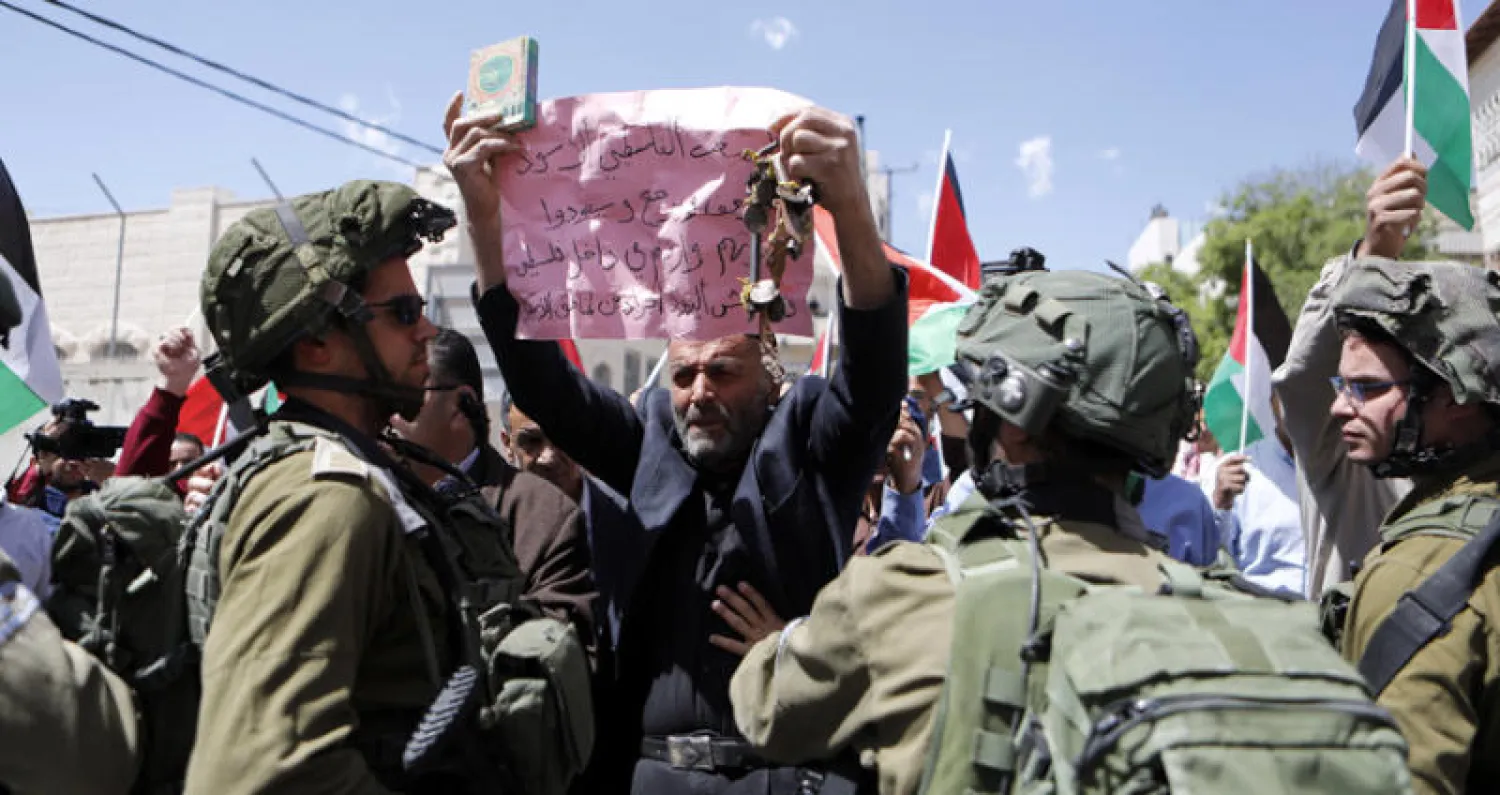 جنود الاحتلال في مواجهة المحتجين في مدينة الخليل أمس (إ.ب.أ)