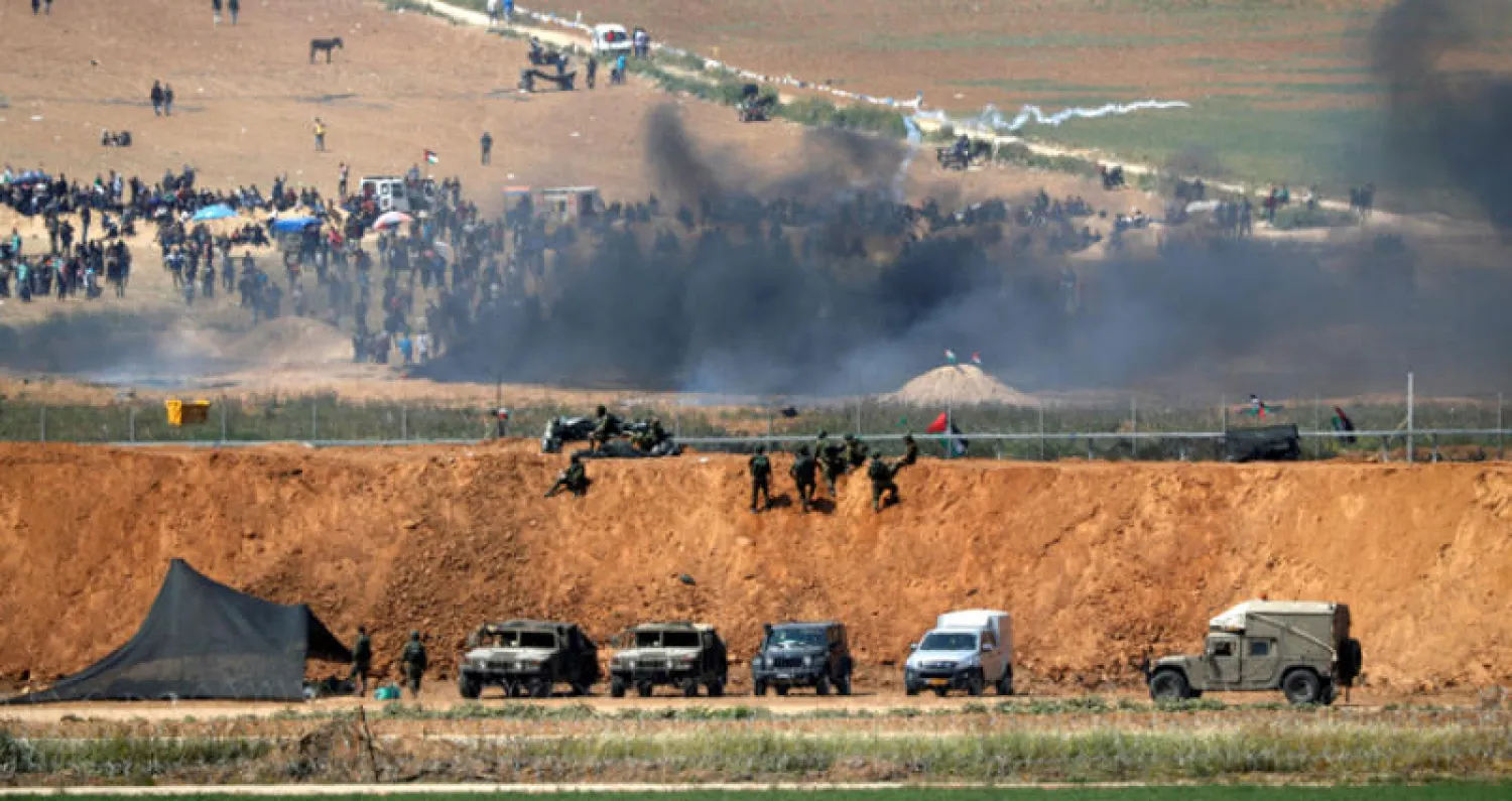 محتجون فلسطينيون يحرقون إطارات في مواجهة جنود الاحتلال على حدود قطاع غزة أمس (أ.ف.ب)