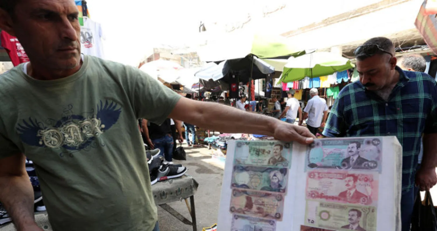 بائع عملة عراقية من عهد الرئيس السابق صدام حسين في سوق الباب الشرقي في بغداد الخميس الماضي (إ.ب.أ)