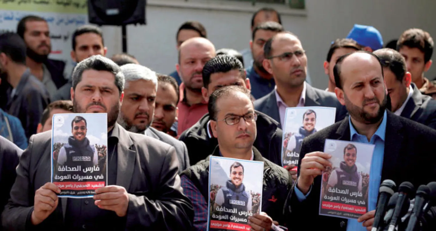 صحافيون يحملون صور زميلهم ياسر مرتجى خلال جنازته في غزة أمس (أ.ف.ب)