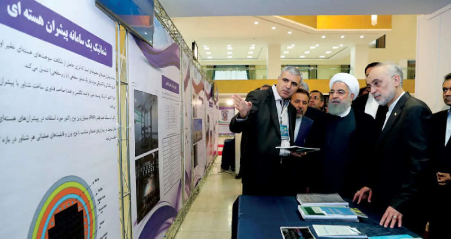 روحاني ورئيس منظمة الطاقة الذرية الإيرانية يستمعان إلى خبير نووي في طهران أمس (موقع روحاني)