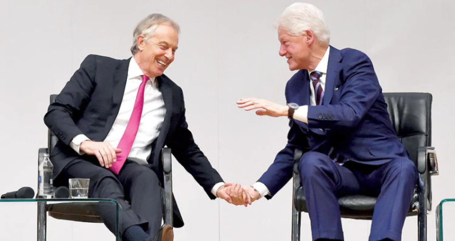 توني بلير (يسار) وبيل كلينتون خلال الاحتفال بالذكرى الـ20 لاتفاق السلام في آيرلندا الشمالية (رويترز)