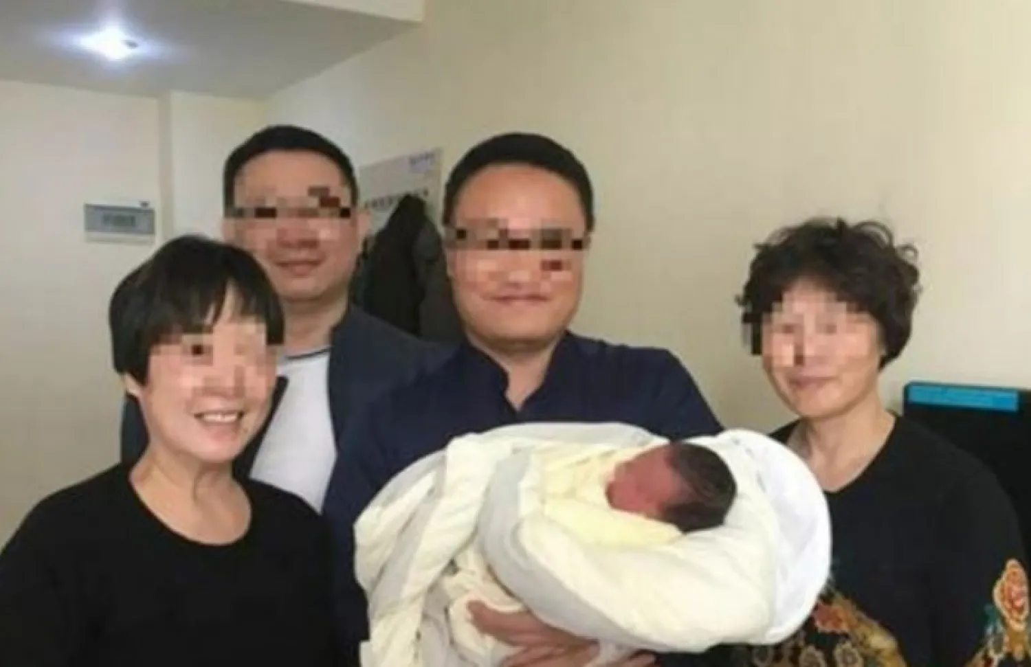 Liu Baojun (center), who runs a surrogacy institute, flanked by the grandmothers of the baby. Photo: Sina