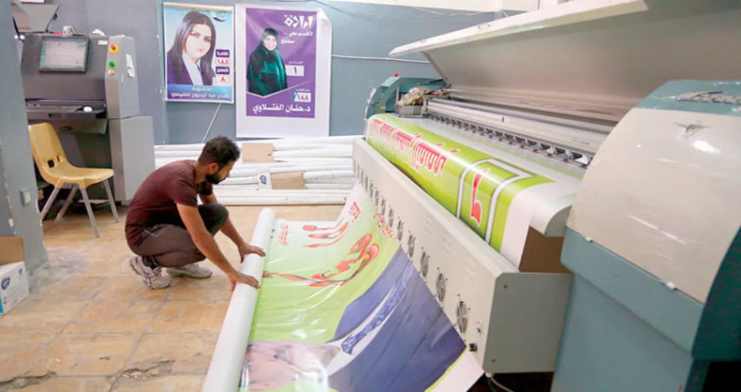 عامل مطبعة في بغداد يطبع ملصقات انتخابية (أ.ب)