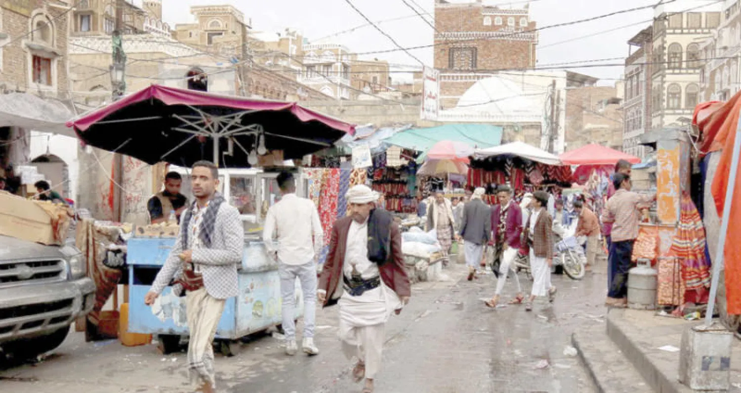 يمنيون يسيرون قرب المدينة القديمة بصنعاء (إ.ب.أ)
