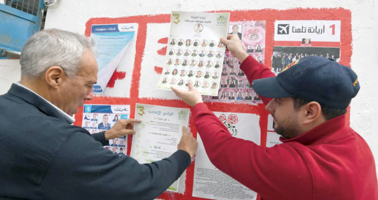 مرشحون مستقلون يضعون لافتات مع بدء حملات الانتخابات البلدية في تونس أمس (أ.ف.ب)