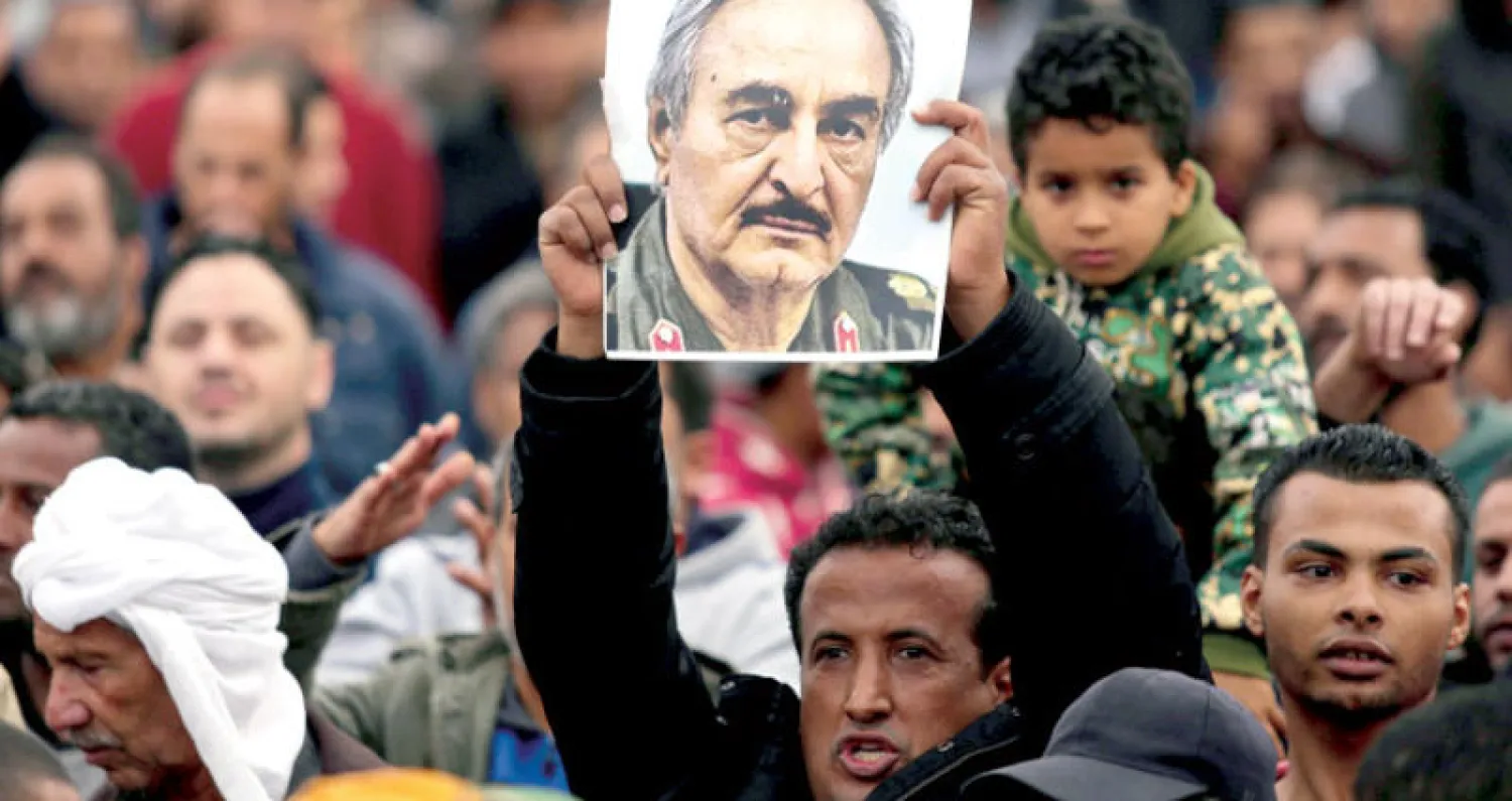 مؤيد للمشير خليفة حفتر يرفع صورته خلال مظاهرة في بنغازي (رويترز)