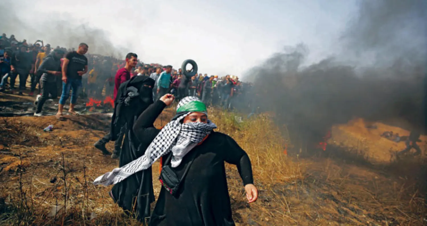 فلسطينيات يشاركن في مواجهات مع قوات الاحتلال على الحدود الشرقية لغزة (إ.ب.أ)