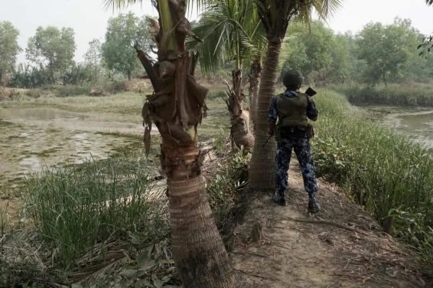 In this photo taken on March 18, 2018, an armed Myanmar borderguard police watches over Bangladesh area from Maungdaw district in Rakhine State on March 18, 2018. / AFP PHOTO / Joe Freeman

