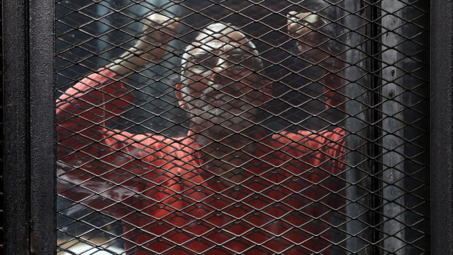 Muslim Brotherhood leader Mohamed Badie shouts slogans behind bars during trial at a court in Cairo. (File photo: Reuters)
