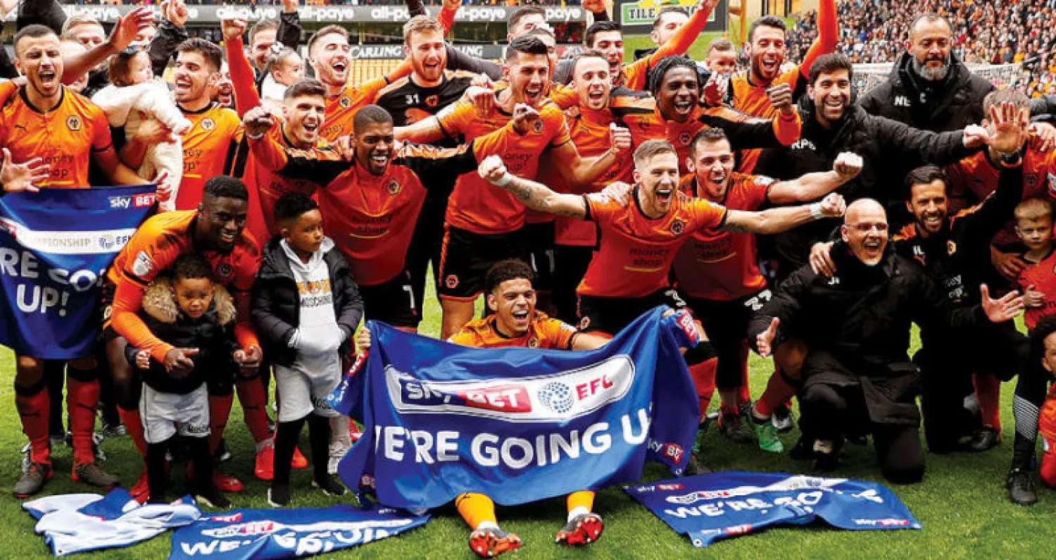 لاعبو وولفرهامبتون وجهازهم الفني يحتفلون بالصعود إلى الدوري الممتاز الإنجليزي (رويترز)