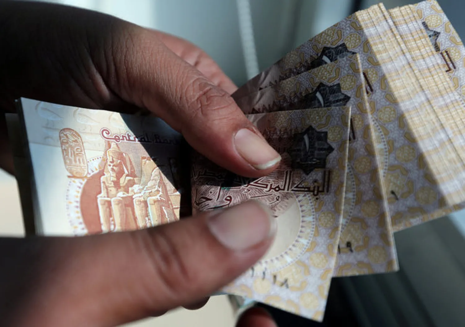 A man counts Egyptian pounds outside a bank in Cairo, Egypt October 24, 2016. REUTERS/Mohamed Abd El Ghany/File Photo
