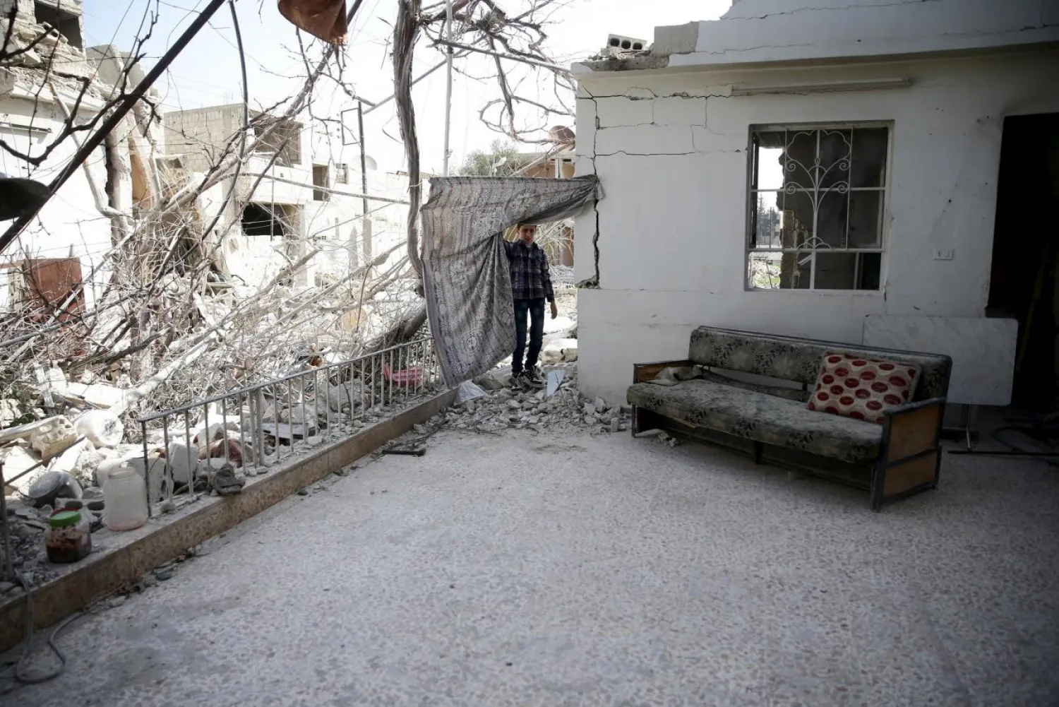 A boy inspects a damaged house in the city of Douma, Syria. (Reuters)