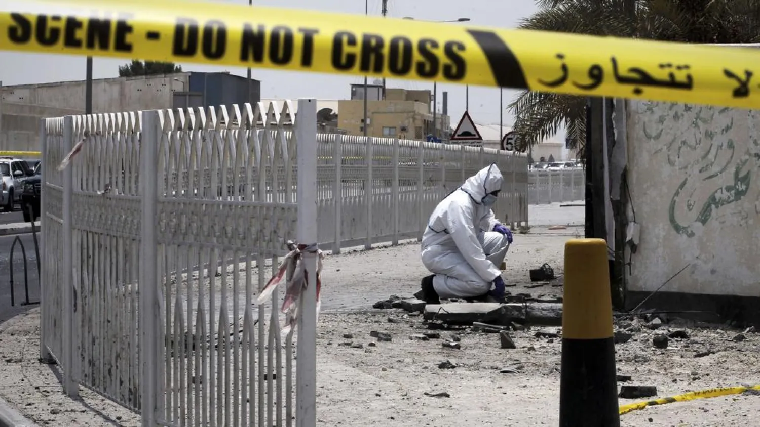 A Bahraini forensic police officer inspects the site of a bomb blast in the village of Sitra, south of Manama in 2017. (AFP)