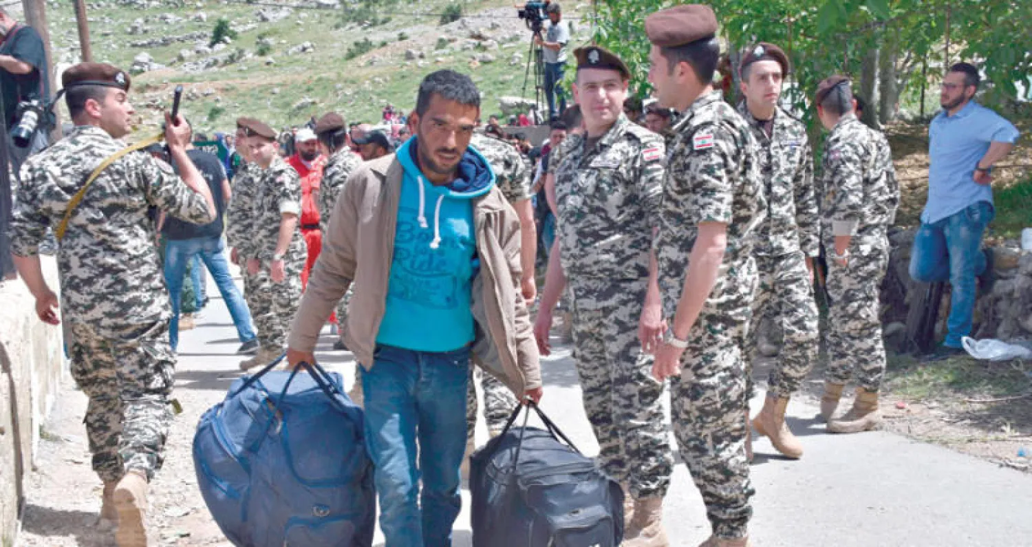 أحد اللاجئين السوريين إلى شبعا يحمل أمتعته في طريق االعودة إلى قريته بيت جن (أ.ب)