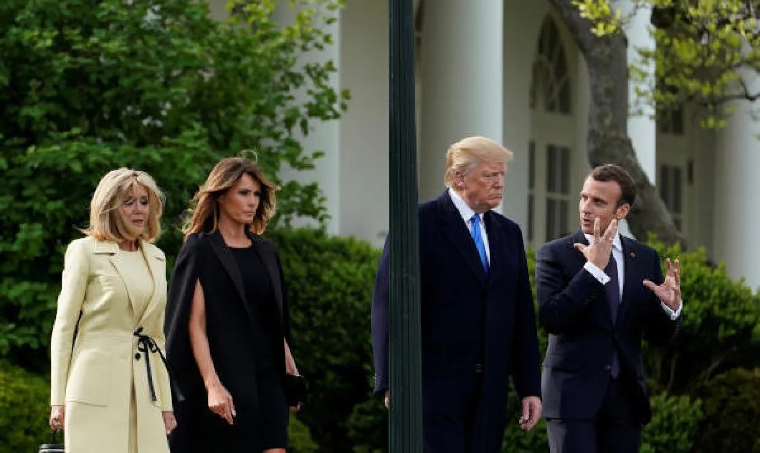 الرئيس الأميركي دونالد ترمب ونظيره الفرنسي إيمانويل ماكرون يسيران مع السيدة الأولى ميلانيا ترمب وبريجيت ماكرون في البيت الأبيض بواشنطن (رويترز)