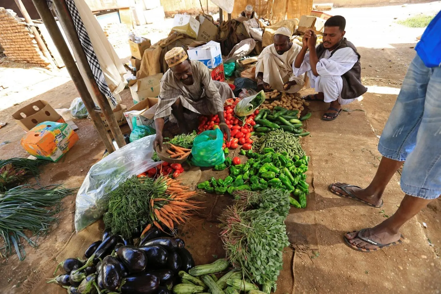 Customers look on as a vendor displays fresh produce in Khartoum, Sudan. (Reuters)