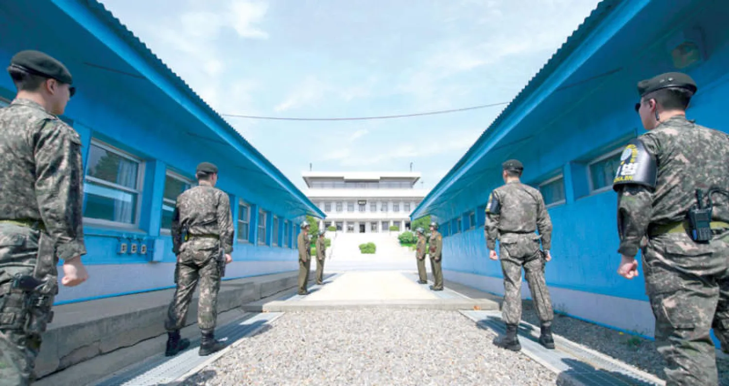 جنود كوريون جنوبيون (في المقدمة) وآخرون شماليون خلال نوبة حراسة أمس أمام القصر الذي سيعقد فيه مون وكيم قمتهما التاريخية اليوم (أ.ف.ب)