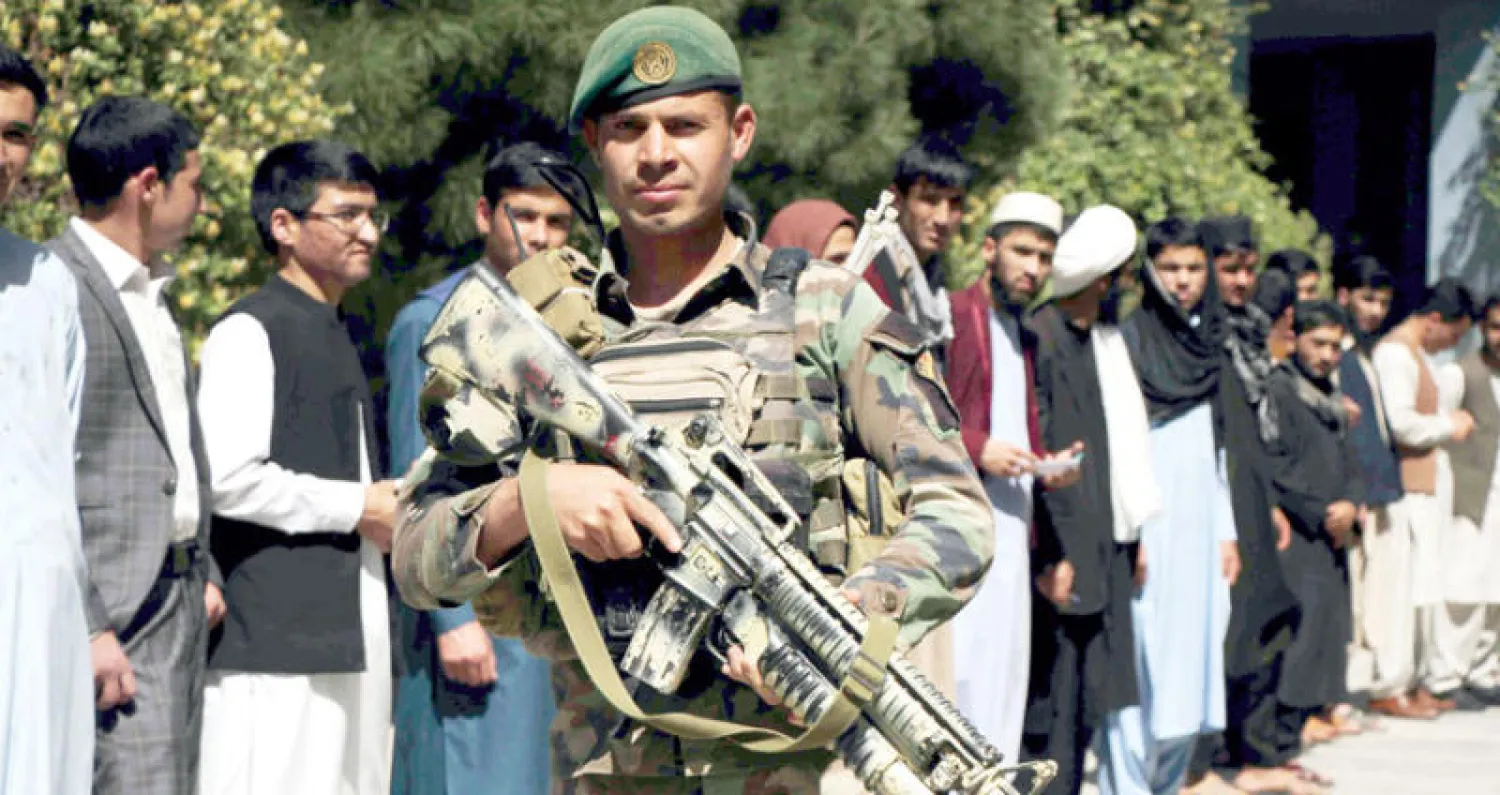 جندي أفغاني يحرس طابوراً من المقترعين الذين جاءوا لتسجيل أسمائهم قبل الانتخابات البرلمانية المقررة في أكتوبر المقبل (إ. ب.أ)