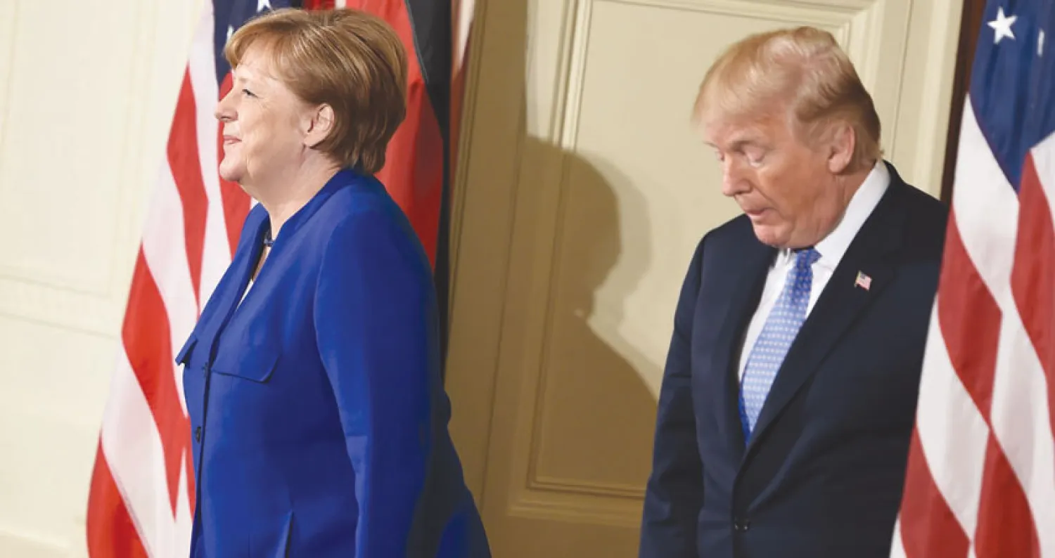 الرئيس الأميركي دونالد ترمب قبل لحظات من مؤتمر صحفي مشترك مع المستشارة الألمانية أنجيلا ميركل في البيت الأبيض الجمعة الماضية (أ.ف.ب)