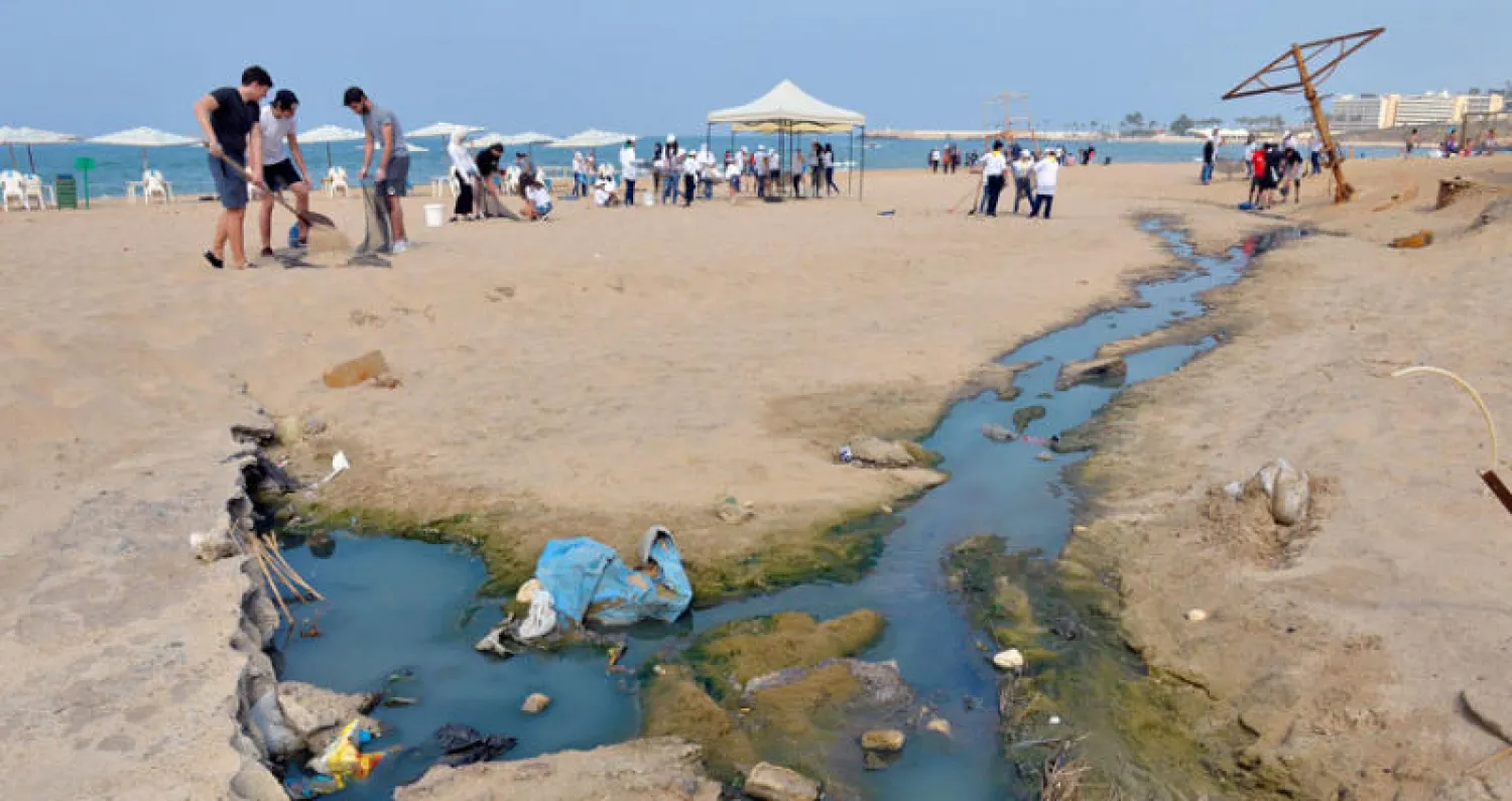 نشطاء يساهمون في تنظيف شاطئ الرملة البيضا في بيروت للفت الانتباه إلى المشاكل البيئية في لبنان (إ.ب.أ)