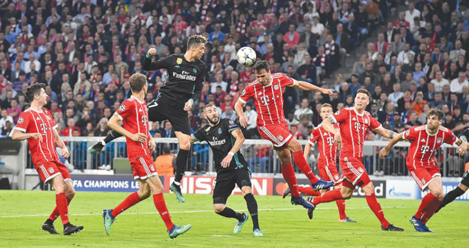 رونالدو نجم ريال مدريد يسدد برأسه وسط لاعبي البايرن خلال لقاء الذهاب (أ.ب)