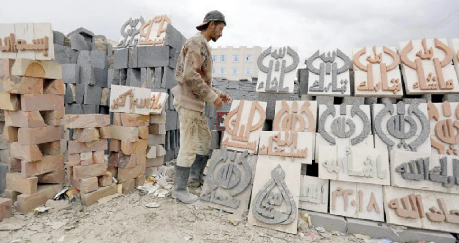 عامل يمني في ورشة للنحت على أحجار البناء في صنعاء أمس (إ.ب.أ)