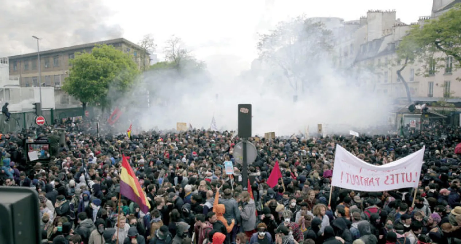 اشتباكات بين متظاهرين وقوات الأمن الفرنسية على هامش مسيرة عيد العمال في باريس أمس (أ.ف.ب)