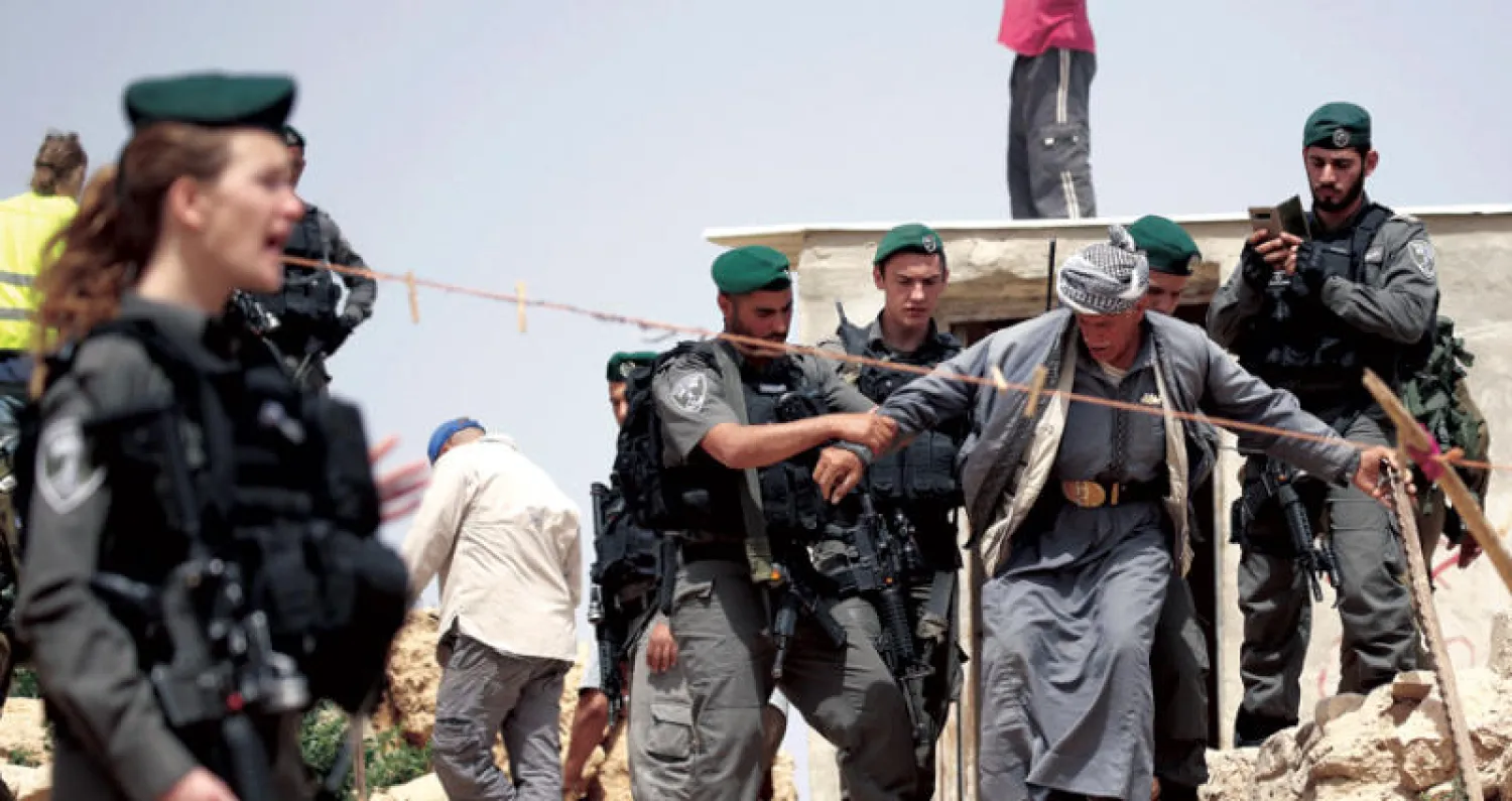 قوات إسرائيلية في مواجهة مع عجوز فلسطيني بعد هدم منزله في الضفة الغربية (إ.ب.أ)