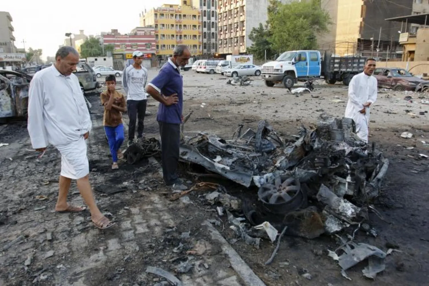 Residents look at wreckage at the site of a car bomb attack in Baghdad, Iraq. Reuters file photo