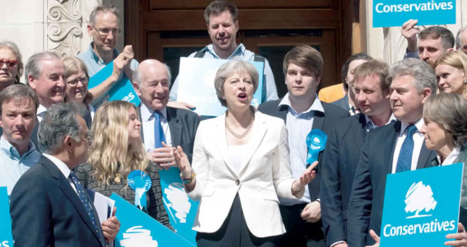 تيريزا ماي محاطة بأنصارها في لندن أمس (أ.ف.ب)