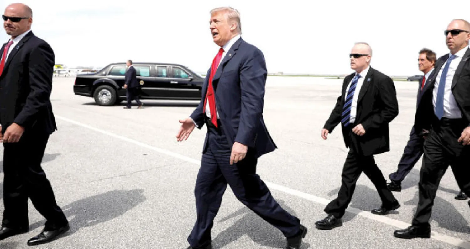 الرئيس دونالد ترمب يحيي مناصرين له عقب نزوله من الطائرة الرئاسية في مطار بكليفلاند في ولاية أوهايو أمس (رويترز)