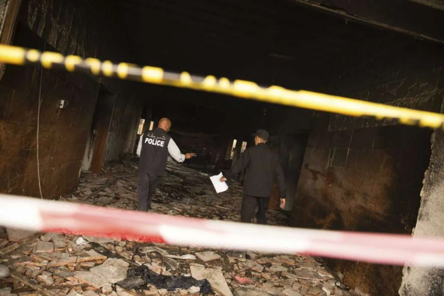Two police officers investigate the building of Libya's high national elections commission in Tripoli after a suicide bombing Wednesday, May 2, 2018. (AP)