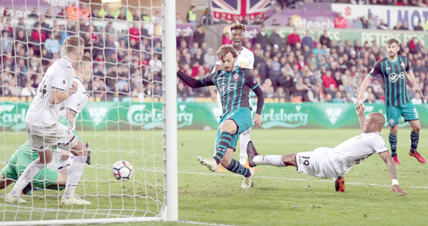 غابياديني مهاجم ساوثهامبتون (في الوسط) يسجل هدف الفوز المهم في مرمى سوانزي (رويترز)